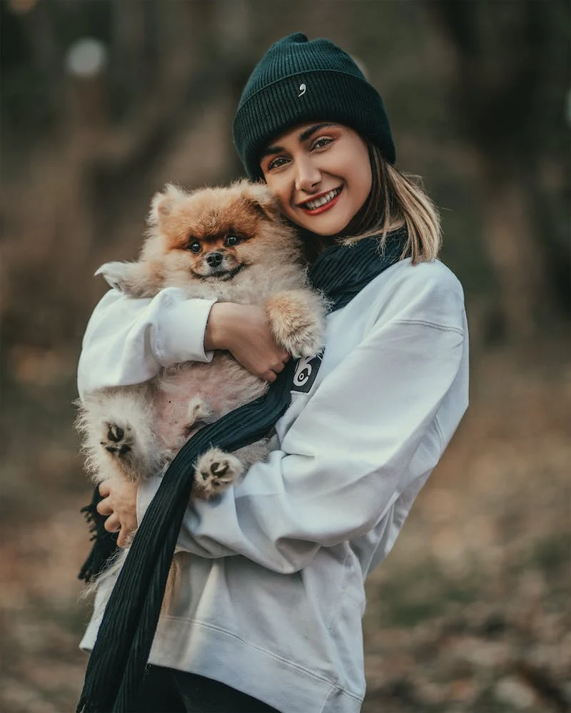Smiling girl holding a small dog